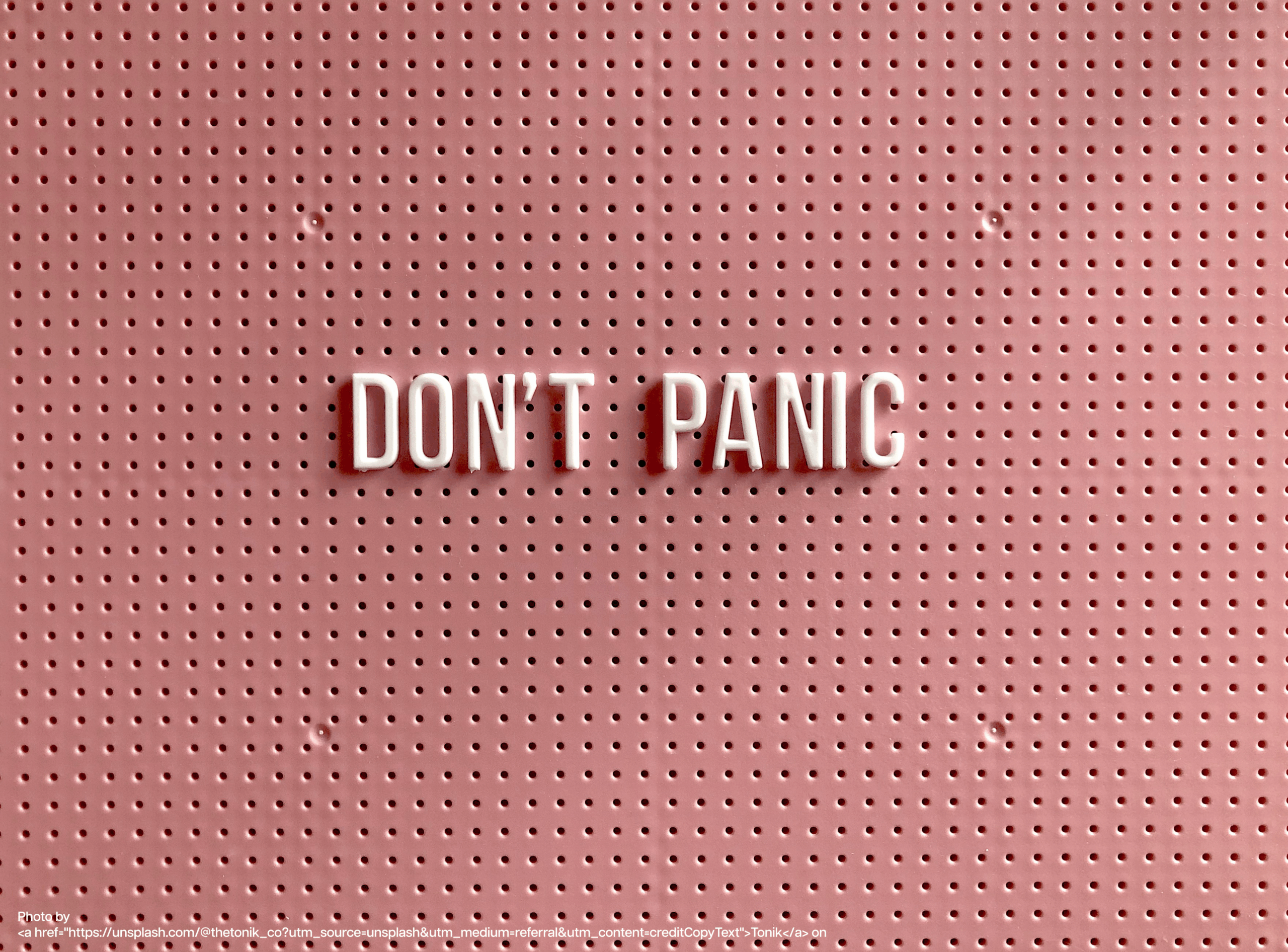 White letters on pink background that say 'Don't Panic'